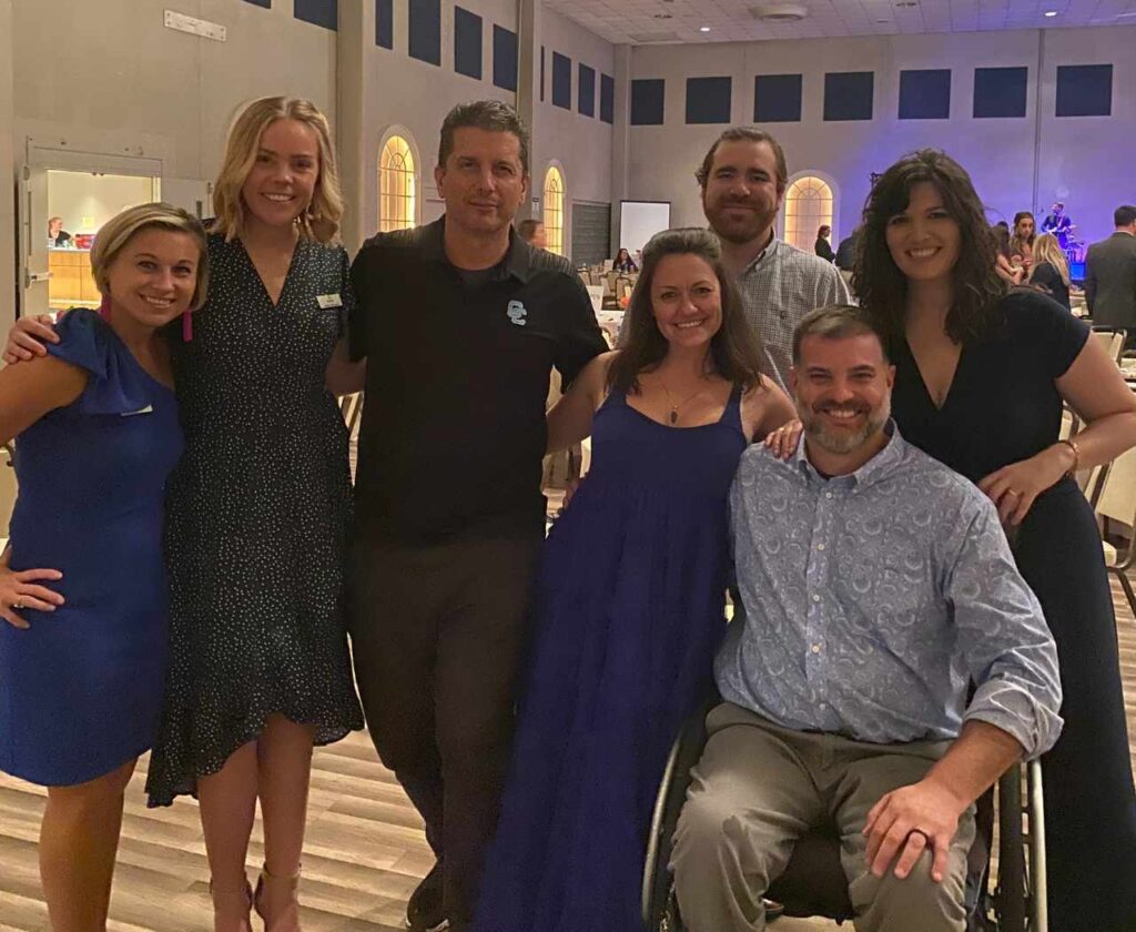 A group of men and women smiling for a picture.